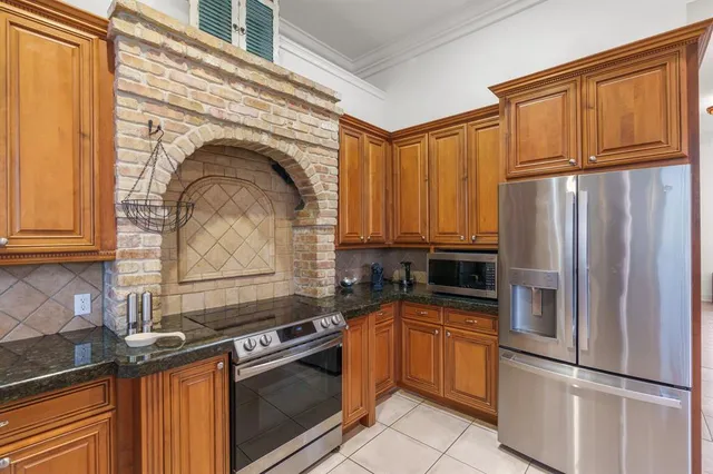a kitchen with granite countertop stainless steel appliances a refrigerator stove and sink