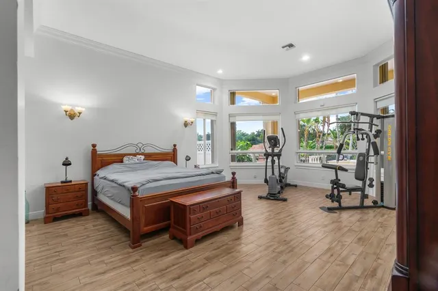 a bedroom with a bed and large windows