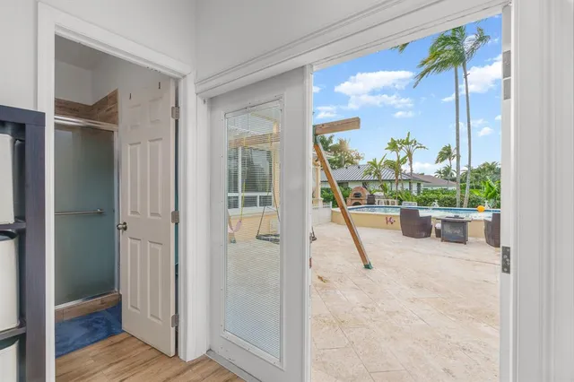 a view of a hallway with wooden floor and a living room