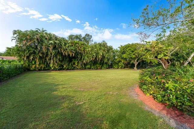 a view of yard with swimming pool and green space