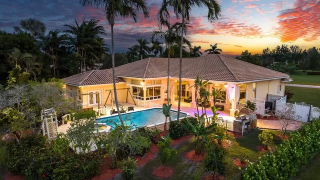 an aerial view of a house with a garden and lake view