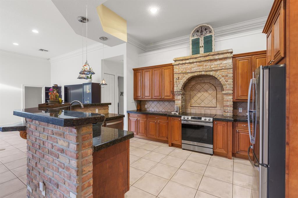 5973 Southwest 54th Court Davie, FL 33314 - Photo 10 of 49 a kitchen with granite countertop a stove top oven sink and stainless steel appliances