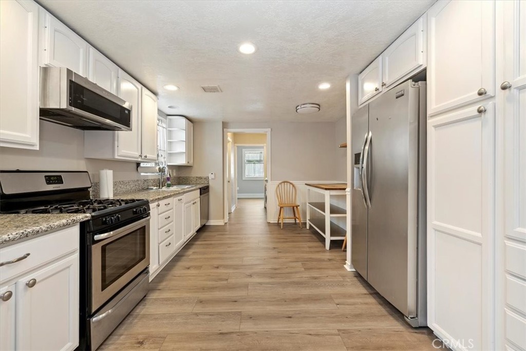 4336 6th Street Riverside, CA 92501 - Photo 7 of 19 a large kitchen with stainless steel appliances granite countertop a stove refrigerator and a microwave