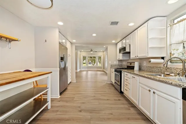 a large kitchen with stainless steel appliances granite countertop a lot of counter space and wooden floor