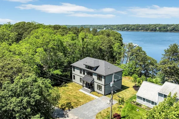 an aerial view of a house with a garden and lake view