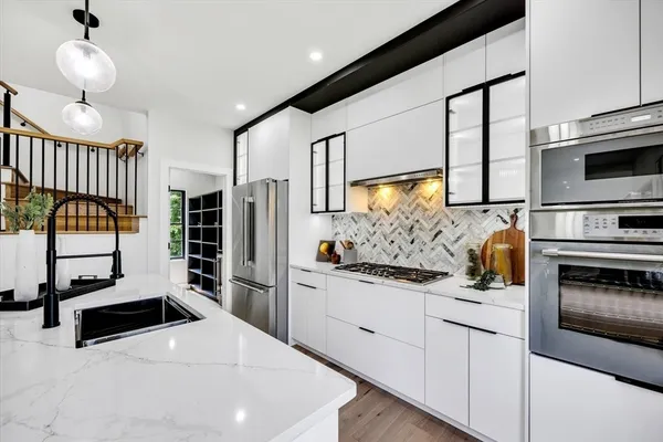 a kitchen with stainless steel appliances kitchen island granite countertop a stove a sink and a microwave