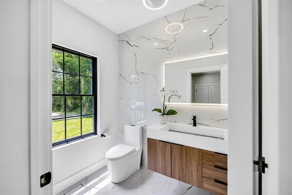 a bathroom with a toilet sink and mirror