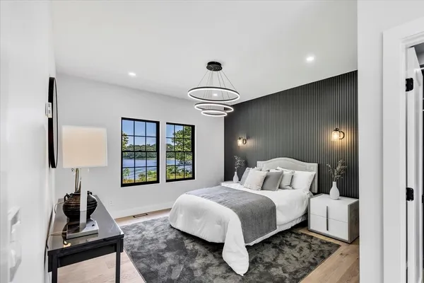 a bedroom with a bed and a large window with balcony view