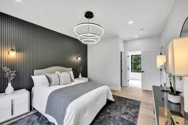 a bedroom with bed and a chandelier