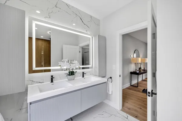 a en suite bathroom with a double vanity sink and a mirror