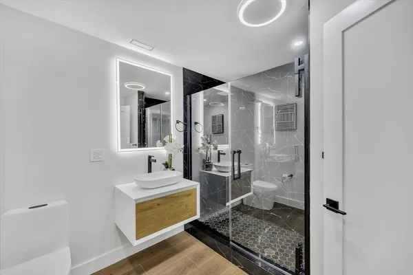 a bathroom with a granite countertop sink a mirror and a shower