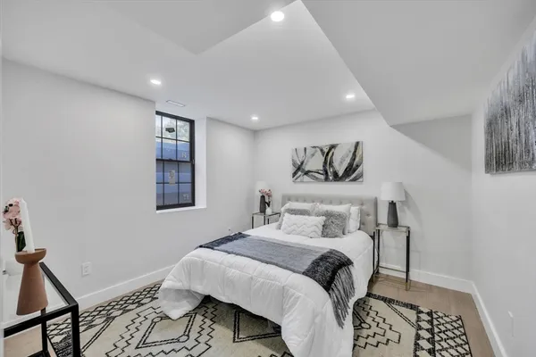 a bedroom with a bed and a lamp with the wooden floor