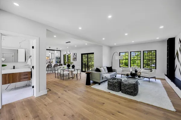 a living room with furniture large window and wooden floor