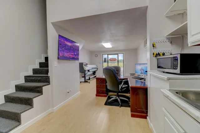 a view of a workspace with furniture and stairs