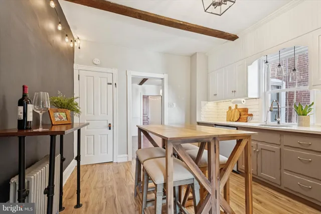 a kitchen with stainless steel appliances granite countertop a table chairs and wooden floors