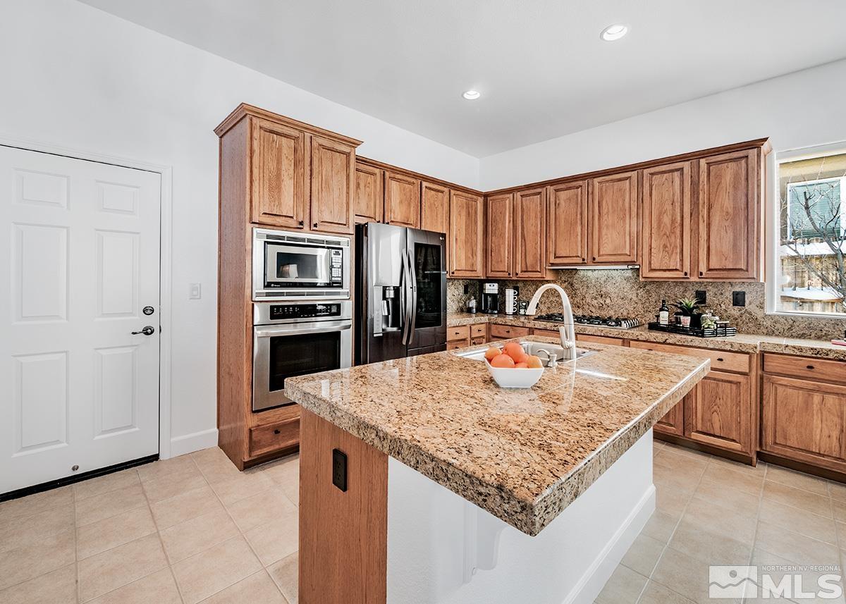 621 Rabbit Ridge Court Reno, NV 89511 - Photo 6 of 26 a kitchen with stainless steel appliances granite countertop a sink refrigerator and cabinets