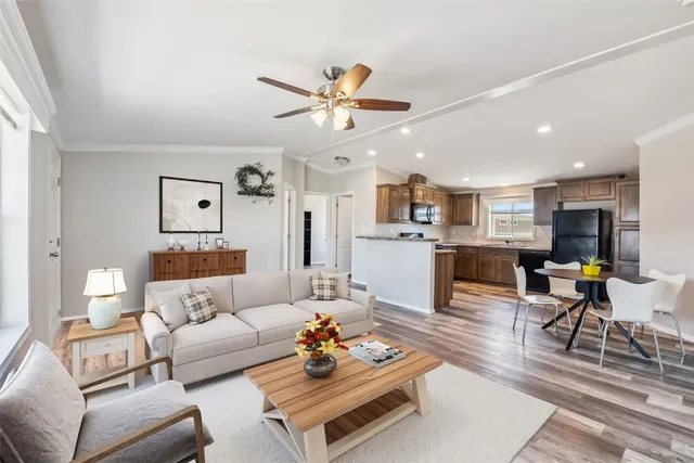 a living room with furniture kitchen view and a chandelier