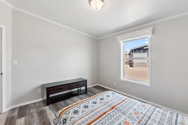 a bedroom with a bed and a lamp with wooden floor