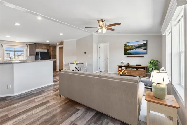 a living room with stainless steel appliances kitchen island furniture and a window
