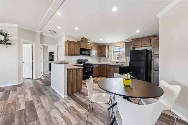 a kitchen with stainless steel appliances kitchen island granite countertop a refrigerator and a stove top oven