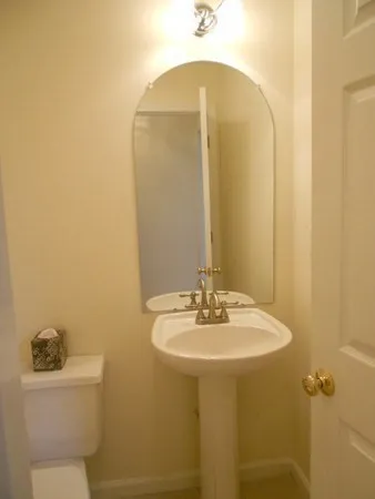 a bathroom with a sink mirror and toilet