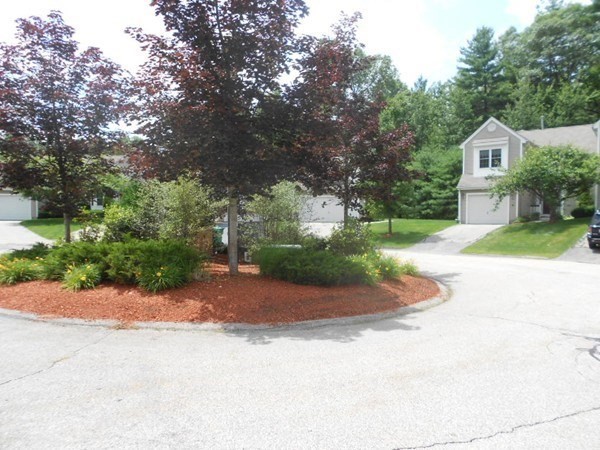 141 Lordvale Boulevard, Unit 141 Grafton, MA 01536 - Photo 3 of 23 a front view of a house with a yard and garage