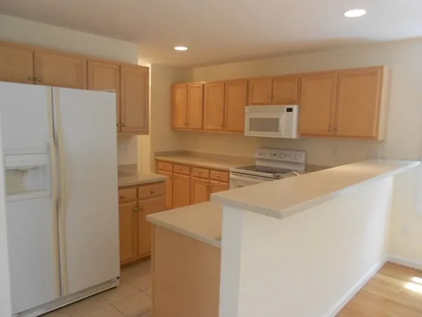 a kitchen with a refrigerator sink and cabinets