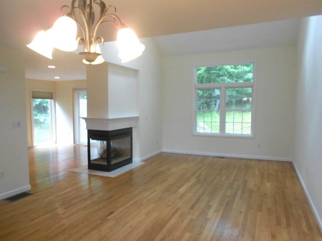 141 Lordvale Boulevard, Unit 141 Grafton, MA 01536 - Photo 9 of 23 wooden floor in an empty room with a window