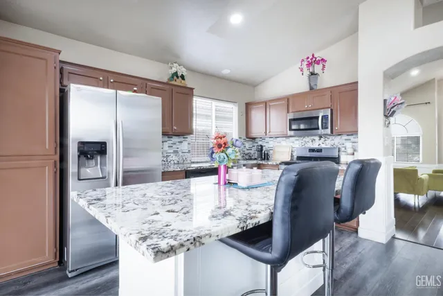 a kitchen with stainless steel appliances granite countertop a stove sink and cabinets