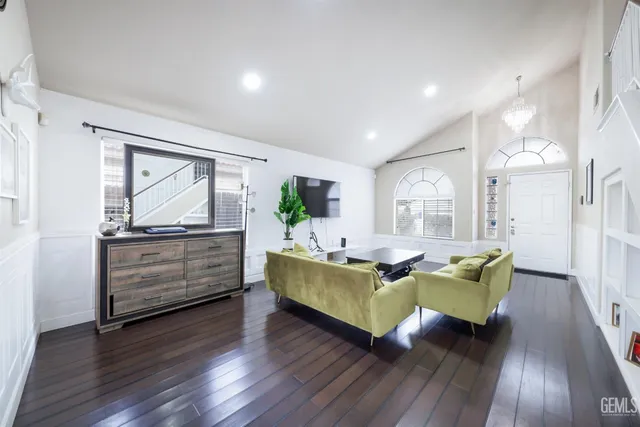 a living room with furniture mirror and wooden floor