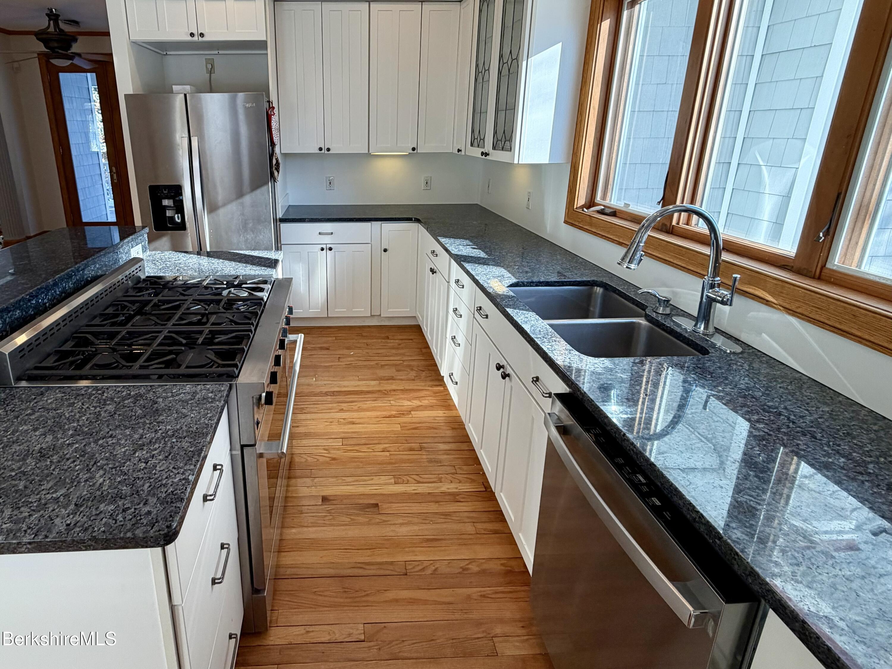 7 Poirot Road Florida, MA 01247 - Photo 14 of 57 a kitchen with granite countertop a sink stove and refrigerator