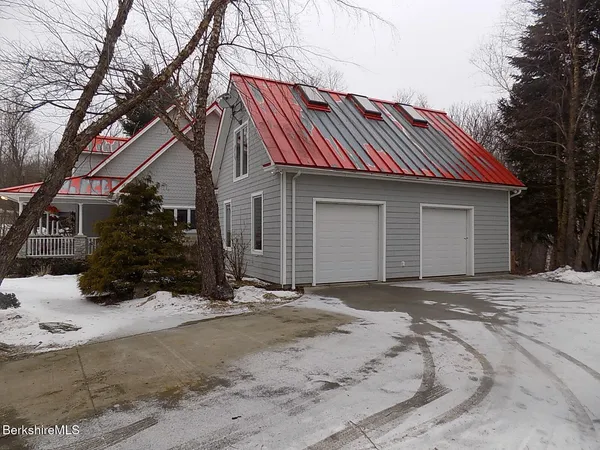 a front view of a house with a yard covered with snow
