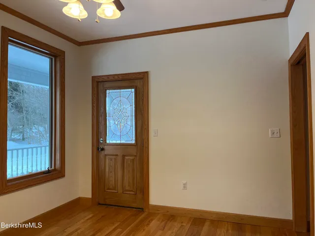 a view of a hallway with wooden floor and staircase