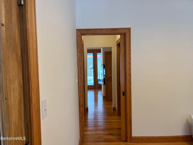an empty room with wooden floor and a ceiling fan
