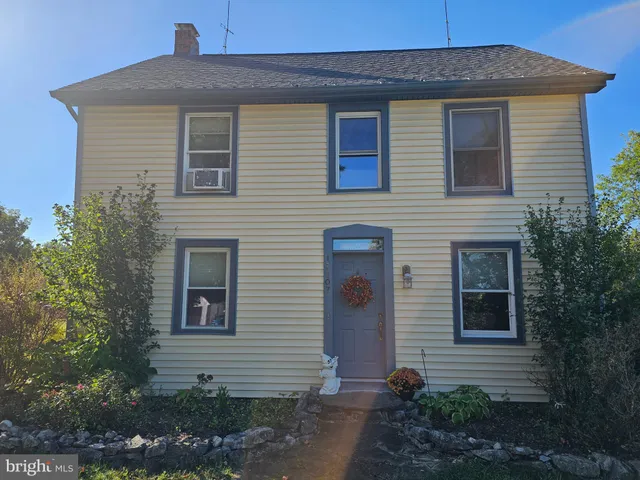 a front view of a house with plants
