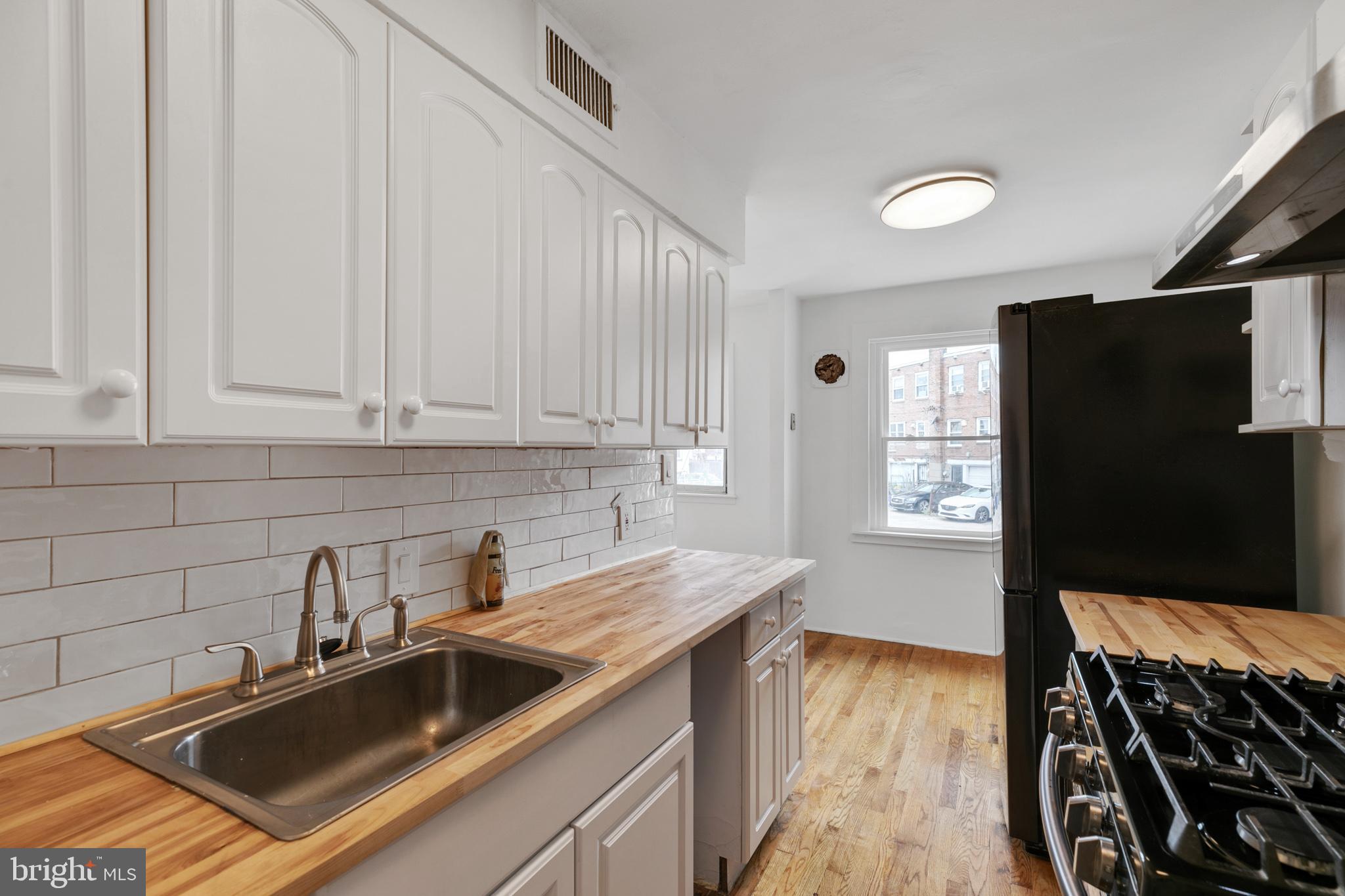 1828 South 29th Street Philadelphia, PA 19145 - Photo 11 of 32 a kitchen that has a sink and a stove in it
