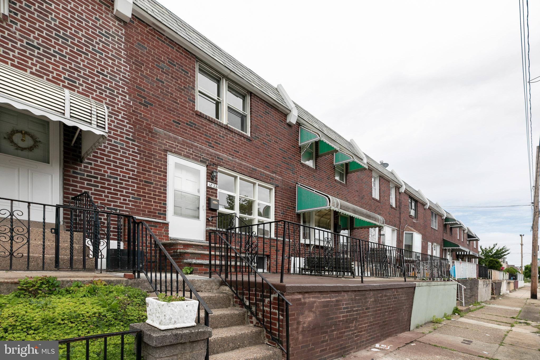 1828 South 29th Street Philadelphia, PA 19145 - Photo 2 of 32 a city street lined with tall buildings and a yard