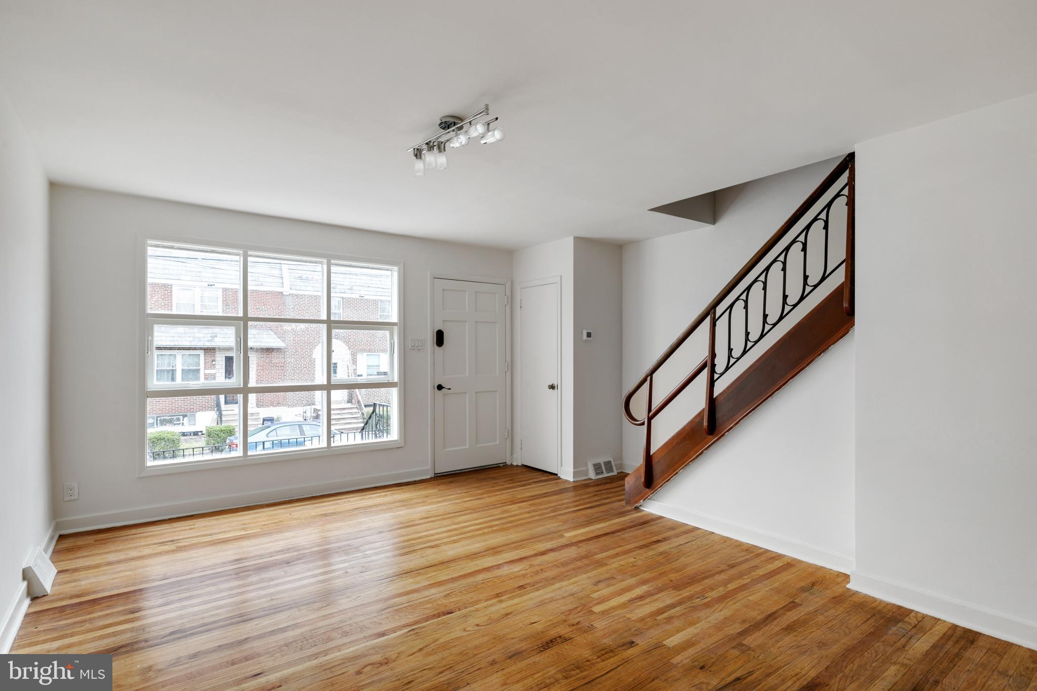 1828 South 29th Street Philadelphia, PA 19145 - Photo 4 of 32 a view of an empty room with wooden floor and fan
