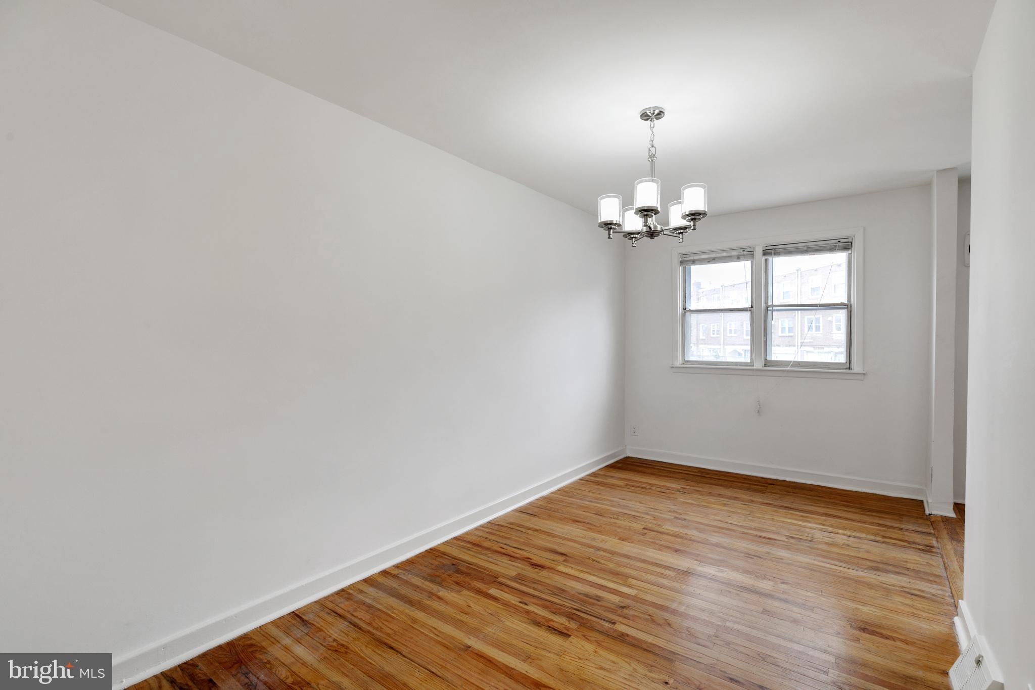 1828 South 29th Street Philadelphia, PA 19145 - Photo 7 of 32 a view of a room with wooden floor chandelier and window