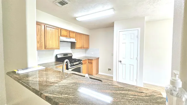 a kitchen with granite countertop a sink cabinets and window