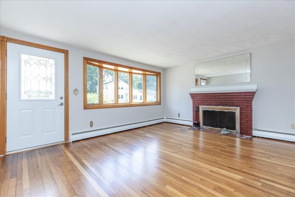35 Rindone Street Holbrook, MA 02343 - Photo 5 of 37 an empty room with wooden floor fireplace and windows
