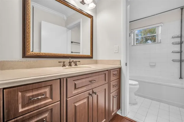 a spacious bathroom with a granite countertop sink a toilet a and mirror