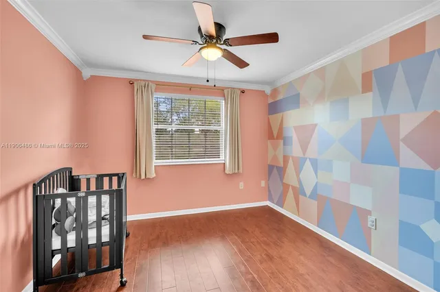 a view of empty room with wooden floor and fan