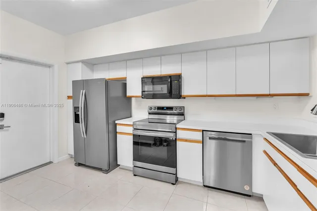 a kitchen with stainless steel appliances granite countertop a refrigerator and a stove top oven
