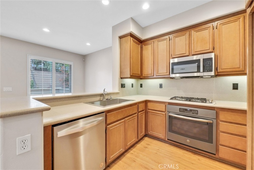 57 Sapphire Irvine, CA 92602 - Photo 2 of 3 a kitchen with stainless steel appliances granite countertop a stove a sink and a microwave