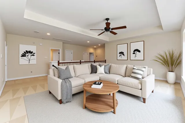 a living room with furniture and a ceiling fan