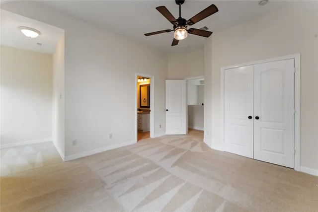 a view of a big room with closet and a ceiling fan