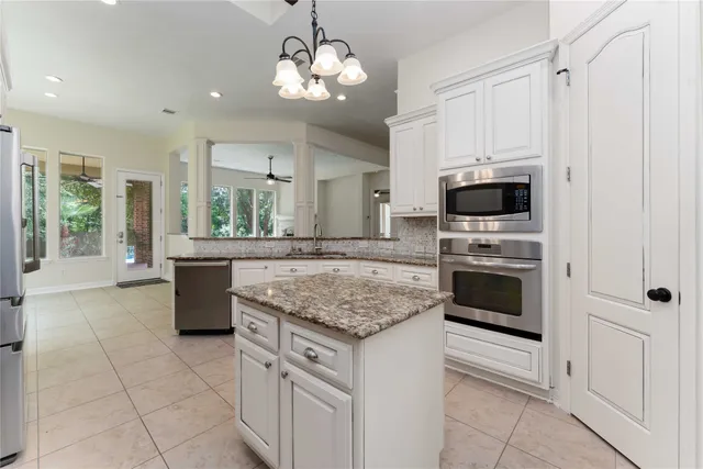 a kitchen with stainless steel appliances granite countertop a stove oven and a white cabinets