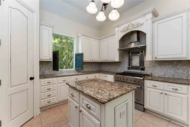 a kitchen with white cabinets and chandelier