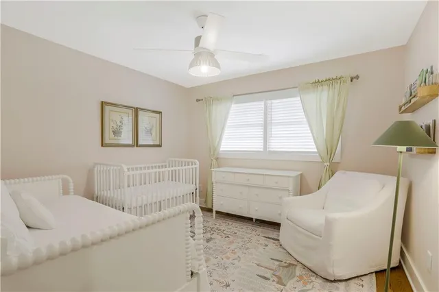 a bedroom with a baby bed a couch and a window